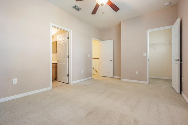14167 Stilton St, Tampa, FL 33626 - unfurnished bedroom with light colored carpet, a walk in closet, connected bathroom, and a ceiling fan