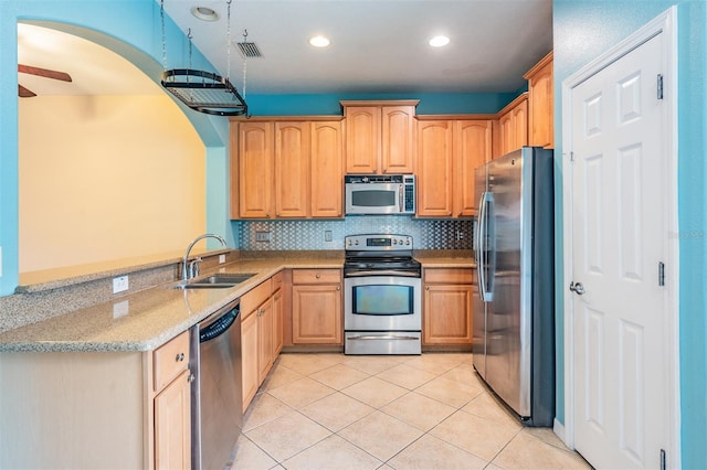 14167 Stilton St, Tampa, FL 33626 - kitchen with stainless steel appliances, light tile patterned floors, tasteful backsplash, light stone countertops, and arched walkways