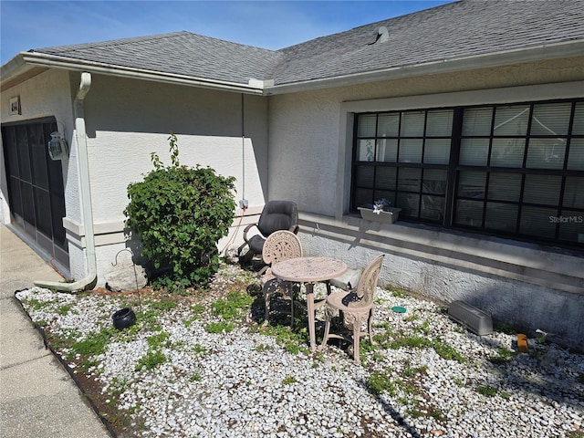 8548 Cypress Lakes Blvd, New Port Richey, FL 34653 - view of side of property featuring roof with shingles, stucco siding, and a garage