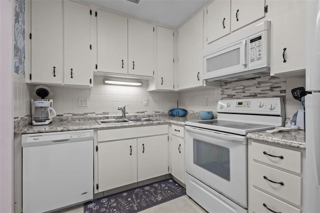 2700 Bayshore Blvd Unit 2312, Dunedin, FL 34698 - kitchen with white appliances, backsplash, light countertops, and white cabinetry