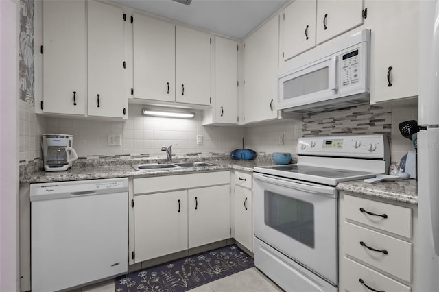 2700 Bayshore Blvd Unit 2312, Dunedin, FL 34698 - kitchen with white appliances, decorative backsplash, light countertops, tile patterned flooring, and white cabinets