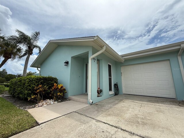 2722 Sherbrooke Ln Unit D, Palm Harbor, FL 34684 - view of front of home with stucco siding, an attached garage, and driveway
