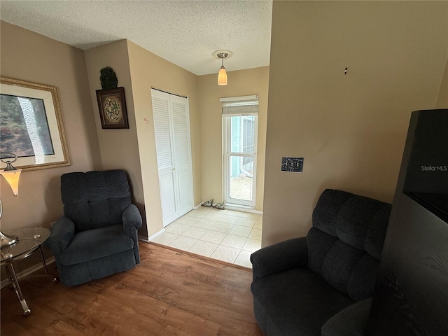 2722 Sherbrooke Ln Unit D, Palm Harbor, FL 34684 - sitting room featuring light wood-style flooring and a textured ceiling