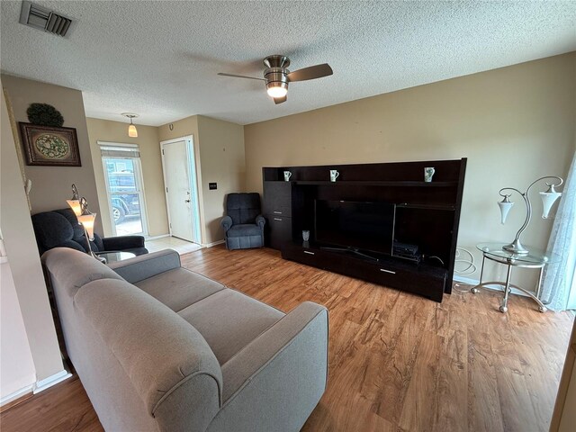 2722 Sherbrooke Ln Unit D, Palm Harbor, FL 34684 - living room with wood finished floors, a ceiling fan, and a textured ceiling