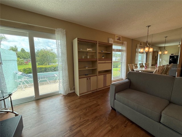 2722 Sherbrooke Ln Unit D, Palm Harbor, FL 34684 - living area with wood finished floors, a textured ceiling, and a chandelier