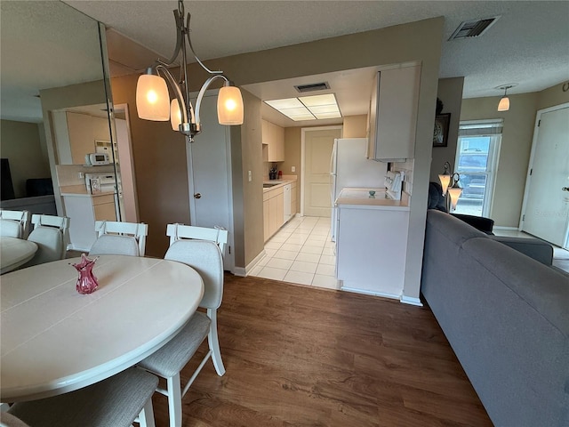 2722 Sherbrooke Ln Unit D, Palm Harbor, FL 34684 - dining space featuring light wood finished floors and a textured ceiling