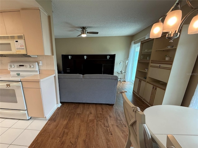 2722 Sherbrooke Ln Unit D, Palm Harbor, FL 34684 - kitchen featuring white appliances, a ceiling fan, light wood-type flooring, light countertops, and a textured ceiling