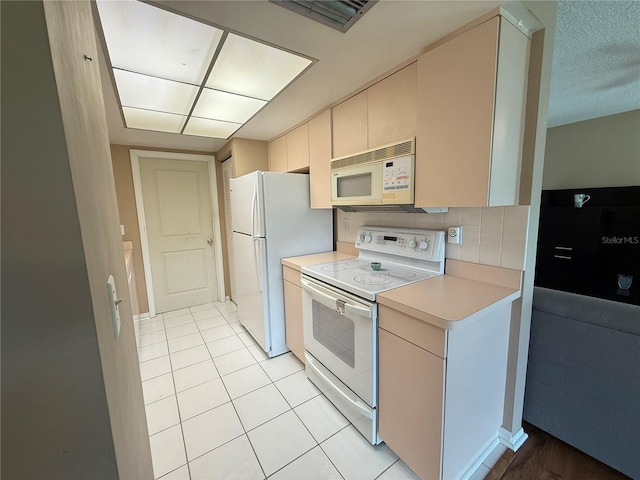 2722 Sherbrooke Ln Unit D, Palm Harbor, FL 34684 - kitchen featuring white appliances, light countertops, cream cabinets, tasteful backsplash, and light tile patterned flooring