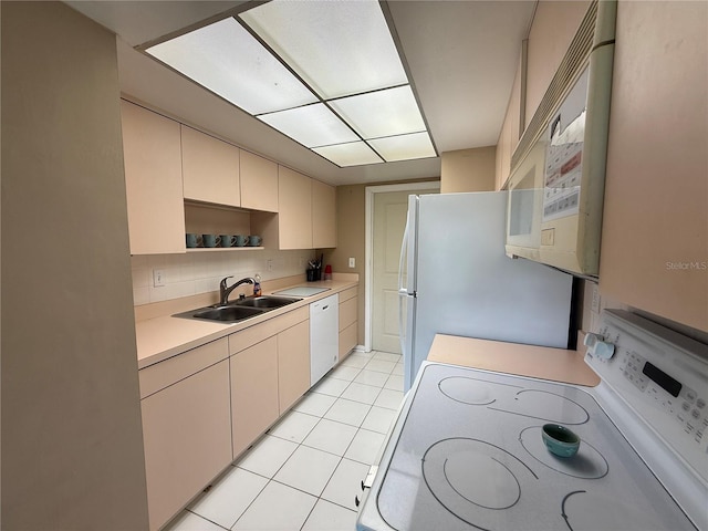 2722 Sherbrooke Ln Unit D, Palm Harbor, FL 34684 - kitchen with white appliances, light countertops, decorative backsplash, light tile patterned flooring, and cream cabinetry