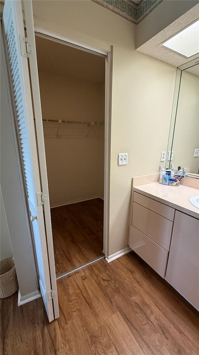 2722 Sherbrooke Ln Unit D, Palm Harbor, FL 34684 - bathroom featuring vanity, wood finished floors, and a spacious closet