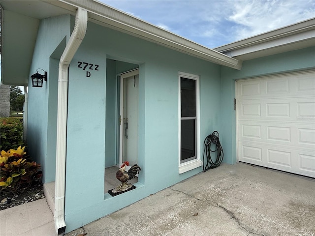 2722 Sherbrooke Ln Unit D, Palm Harbor, FL 34684 - entrance to property with a garage and stucco siding