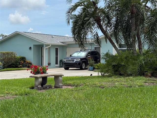 2722 Sherbrooke Ln Unit D, Palm Harbor, FL 34684 - view of side of home with stucco siding, driveway, a garage, and a yard