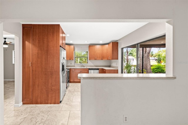 2986 Cypress Green Dr, Palm Harbor, FL 34684 - kitchen featuring light countertops, stainless steel appliances, a peninsula, brown cabinetry, and recessed lighting