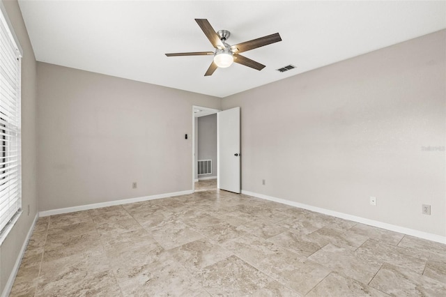 2986 Cypress Green Dr, Palm Harbor, FL 34684 - unfurnished room with a ceiling fan, plenty of natural light, and light stone finish flooring
