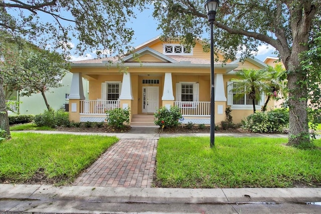 7310 S Shamrock Rd, Tampa, FL 33616 - view of front facade with a porch, stucco siding, and a front yard