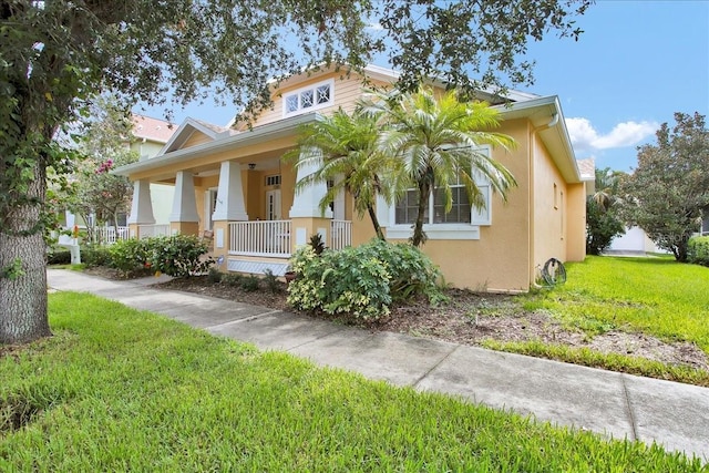 7310 S Shamrock Rd, Tampa, FL 33616 - view of front of house with covered porch, stucco siding, and a front yard