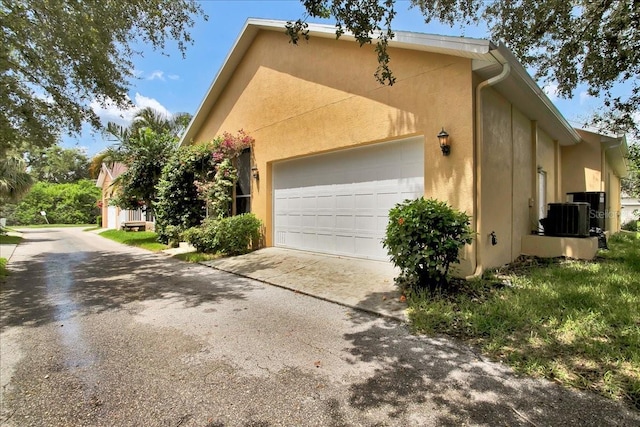 7310 S Shamrock Rd, Tampa, FL 33616 - view of side of home featuring concrete driveway, a garage, and stucco siding