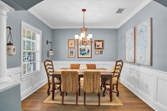 7310 S Shamrock Rd, Tampa, FL 33616 - dining room featuring ornamental molding, dark wood-style floors, a chandelier, wainscoting, and decorative columns