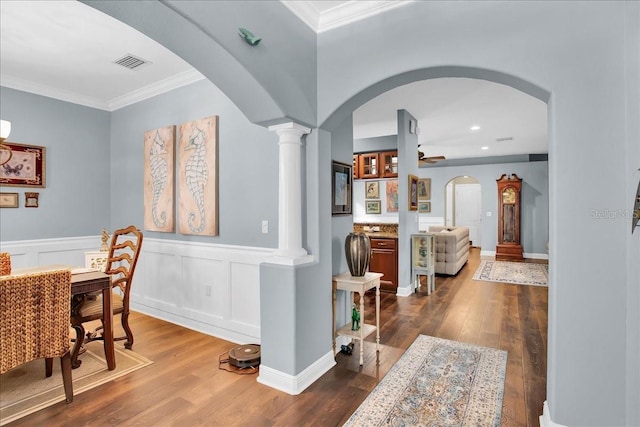 7310 S Shamrock Rd, Tampa, FL 33616 - dining area featuring arched walkways, crown molding, dark wood-style floors, wainscoting, and a ceiling fan