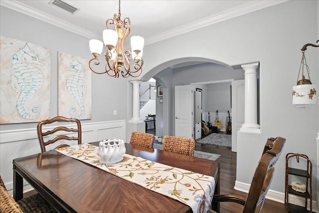 7310 S Shamrock Rd, Tampa, FL 33616 - dining area featuring arched walkways, crown molding, ornate columns, a chandelier, and wainscoting