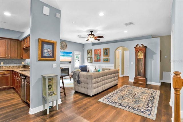 7310 S Shamrock Rd, Tampa, FL 33616 - living room featuring arched walkways, a ceiling fan, dark wood-type flooring, recessed lighting, and a glass covered fireplace
