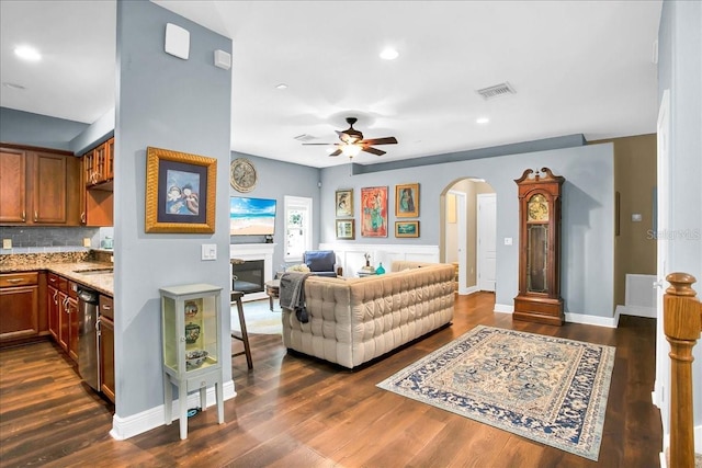 7310 S Shamrock Rd, Tampa, FL 33616 - living room featuring arched walkways, ceiling fan, dark wood-style floors, recessed lighting, and a glass covered fireplace