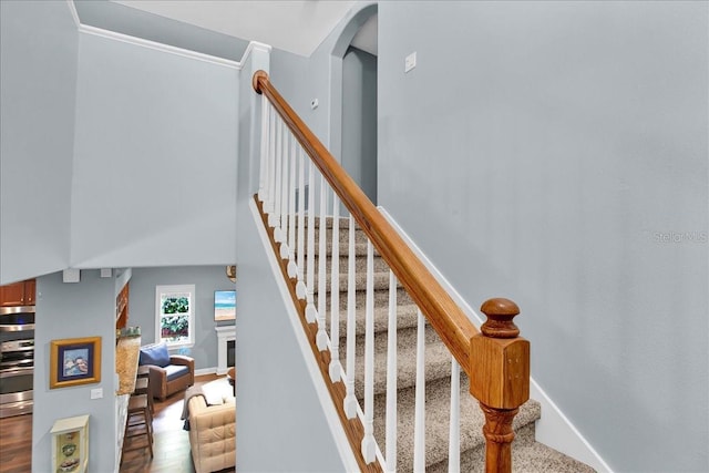 7310 S Shamrock Rd, Tampa, FL 33616 - stairway featuring a fireplace, crown molding, and a high ceiling