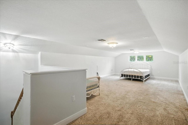 7310 S Shamrock Rd, Tampa, FL 33616 - bedroom featuring vaulted ceiling, carpet flooring, and a textured ceiling