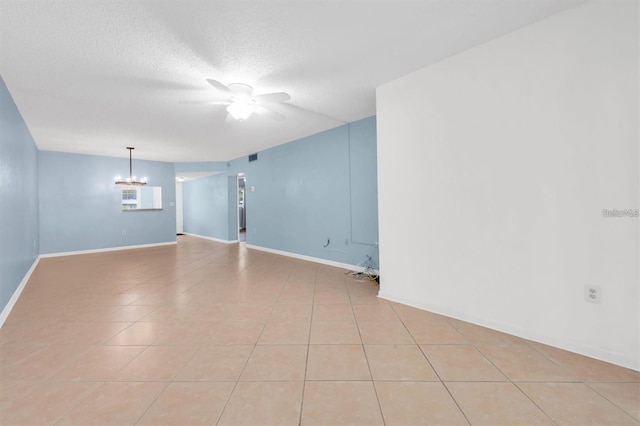 845 Maple Ct Unit 103, Dunedin, FL 34698 - empty room featuring a ceiling fan, a chandelier, light tile patterned floors, and a textured ceiling