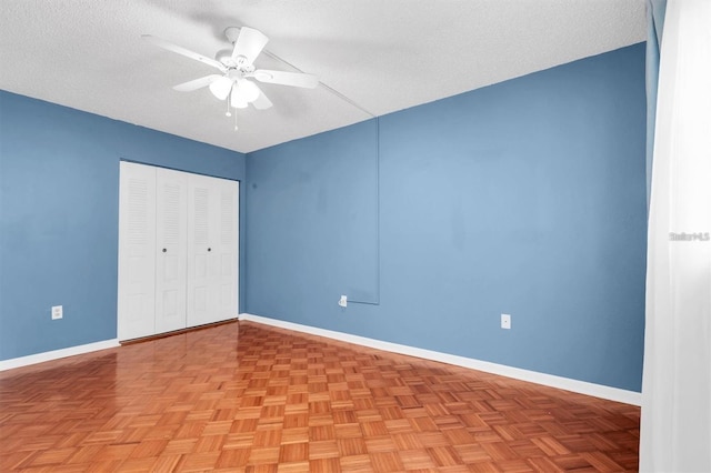845 Maple Ct Unit 103, Dunedin, FL 34698 - unfurnished bedroom featuring a closet, a textured ceiling, and a ceiling fan