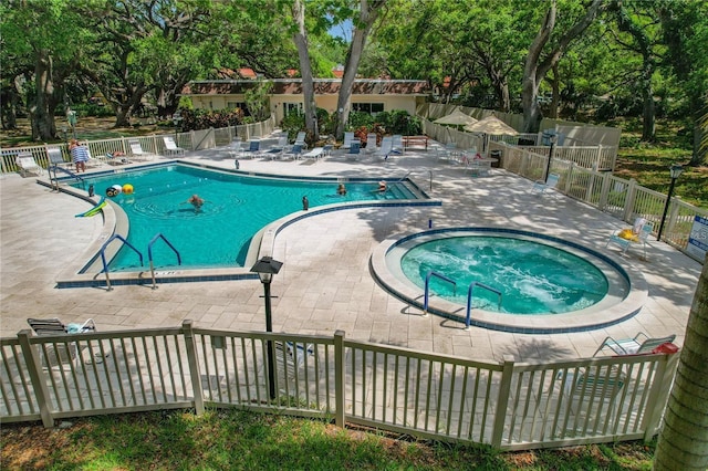 845 Maple Ct Unit 103, Dunedin, FL 34698 - community pool with a community hot tub, a patio, and view of wooded area