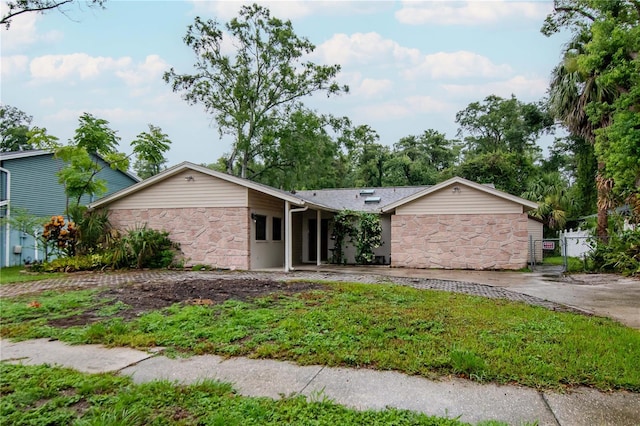 3129 W Paris St, Tampa, FL 33614 - view of front of property featuring stone siding, a gate, and concrete driveway