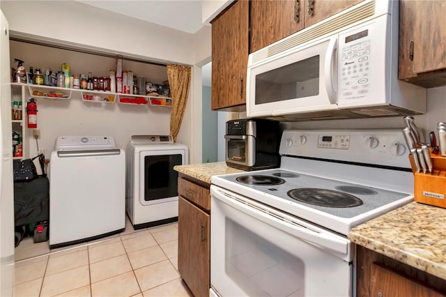 3129 W Paris St, Tampa, FL 33614 - kitchen with white appliances, washing machine and clothes dryer, and brown cabinetry