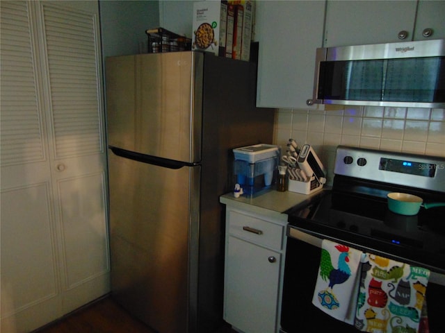 1250 S Pinellas Ave Unit 307, Tarpon Springs, FL 34689 - kitchen with stainless steel appliances, backsplash, light countertops, and white cabinets