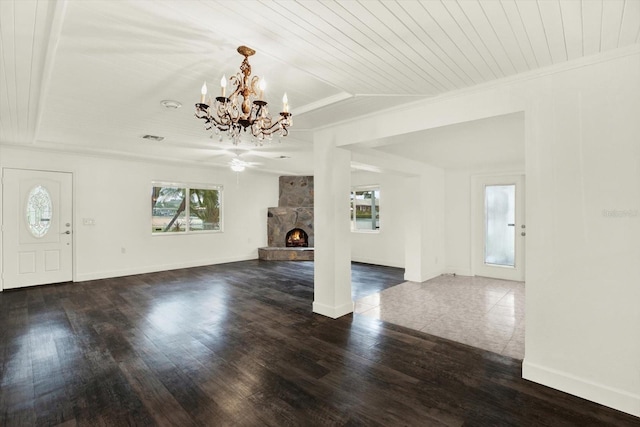102 W N Branch Rd, Ruskin, FL 33570 - unfurnished living room featuring a chandelier, wood ceiling, a stone fireplace, a raised ceiling, and dark wood-type flooring