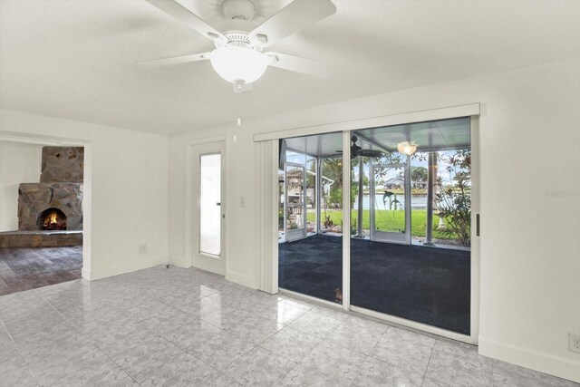 102 W N Branch Rd, Ruskin, FL 33570 - spare room featuring a stone fireplace and a ceiling fan