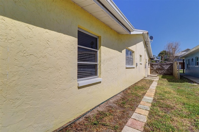 123 11th Ave, Indian Rocks Beach, FL 33785 - view of home's exterior with stucco siding and a gate