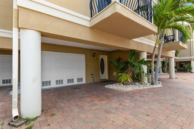 300 Capri Blvd Unit 3, Treasure Island, FL 33706 - doorway to property with stucco siding, a garage, and a balcony