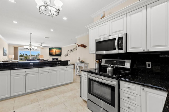 300 Capri Blvd Unit 3, Treasure Island, FL 33706 - kitchen with appliances with stainless steel finishes, a chandelier, crown molding, white cabinetry, and light tile patterned floors