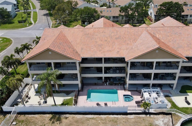300 Capri Blvd Unit 3, Treasure Island, FL 33706 - back of house featuring a fenced backyard, a patio area, a community pool, and a tiled roof