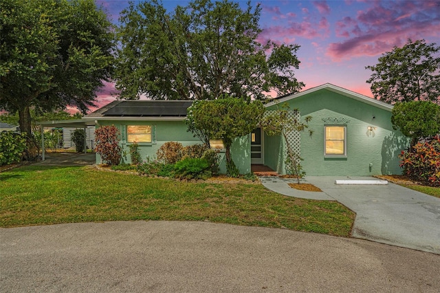 6131 17th St, Zephyrhills, FL 33542 - ranch-style home with stucco siding, a yard, and roof mounted solar panels