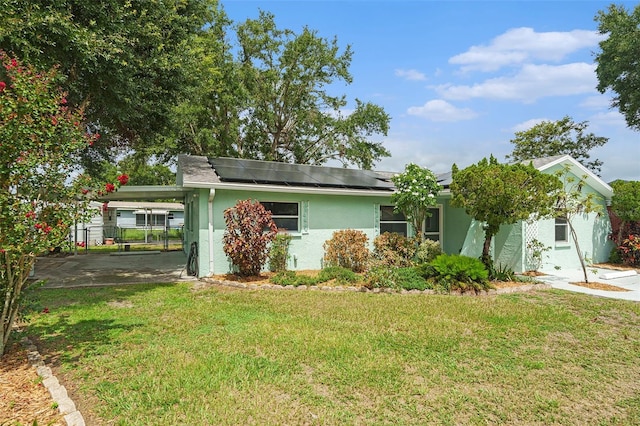 6131 17th St, Zephyrhills, FL 33542 - view of front of house featuring stucco siding, roof mounted solar panels, and an attached carport