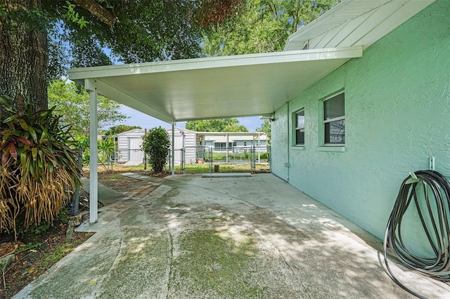 6131 17th St, Zephyrhills, FL 33542 - view of patio / terrace with a storage unit, a gate, and an attached carport