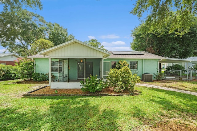6131 17th St, Zephyrhills, FL 33542 - single story home with a sunroom, solar panels, a carport, a gate, and stucco siding