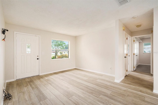 6131 17th St, Zephyrhills, FL 33542 - entrance foyer with light wood-type flooring and a textured ceiling