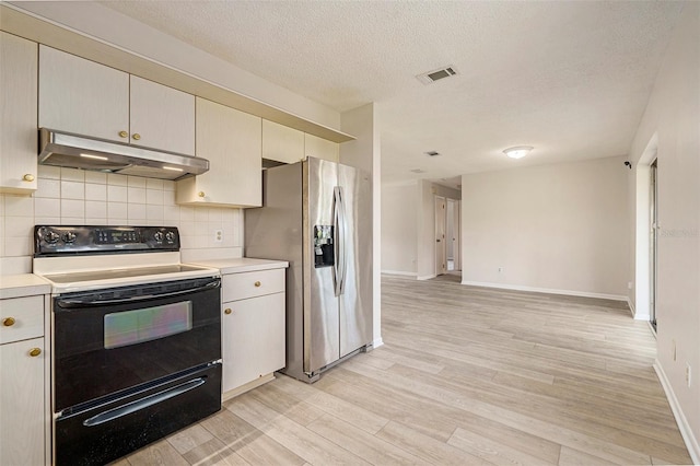 6131 17th St, Zephyrhills, FL 33542 - kitchen with under cabinet range hood, electric stove, stainless steel refrigerator with ice dispenser, light countertops, and light wood finished floors