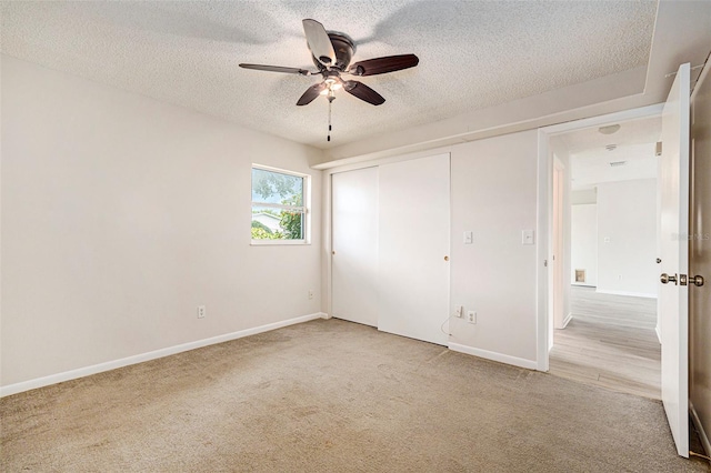 6131 17th St, Zephyrhills, FL 33542 - unfurnished bedroom with carpet flooring, a textured ceiling, a closet, and a ceiling fan