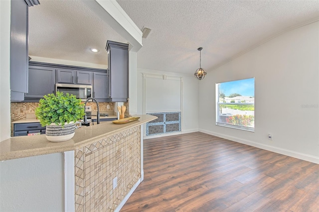 10505 Goldwater Ln, Riverview, FL 33578 - kitchen with stainless steel microwave, a textured ceiling, backsplash, dark wood-style flooring, and gray cabinetry