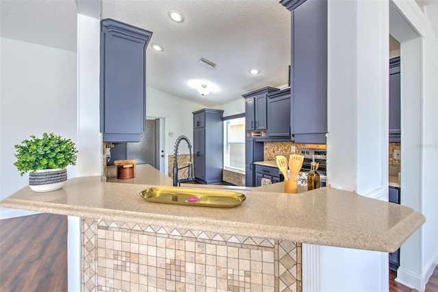 10505 Goldwater Ln, Riverview, FL 33578 - kitchen featuring lofted ceiling, a textured ceiling, a peninsula, light countertops, and wood finished floors