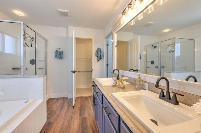 10505 Goldwater Ln, Riverview, FL 33578 - bathroom with a shower stall, a garden tub, double vanity, and wood finished floors